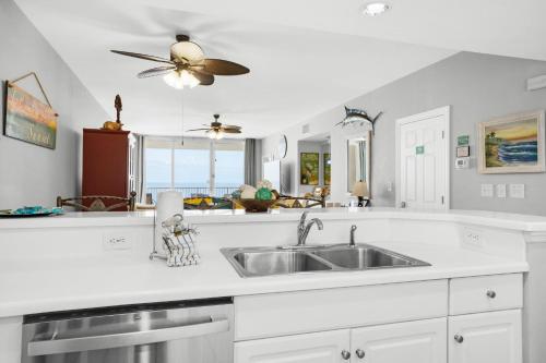 a kitchen with a sink and a ceiling fan at Majestic Beach Towers 2-909 in Panama City Beach