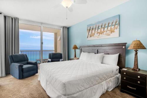a bedroom with a bed and a chair and a window at Majestic Beach Towers 2-909 in Panama City Beach