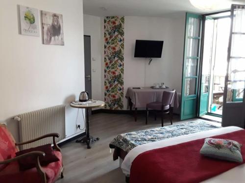 a hotel room with a bed and a table and window at Madelon IV in Belvès