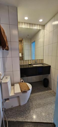La salle de bains est pourvue de toilettes et d'un grand miroir. dans l'établissement Oasis Rentals, Diana Estate, Pattaya, à Pattaya