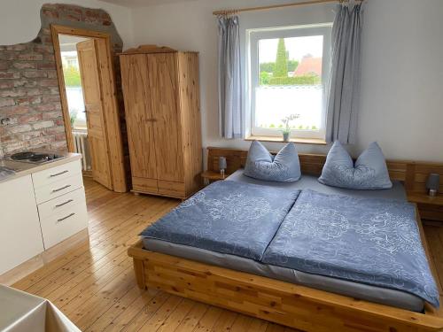 um quarto com uma cama com lençóis azuis e uma janela em Pension Landhaus an der Saale em Bernburg
