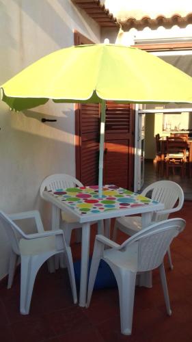 Acquafredda House - Appartamento Primo Piano في أكوافريدا: طاولة مع مظلة صفراء وكرسيين