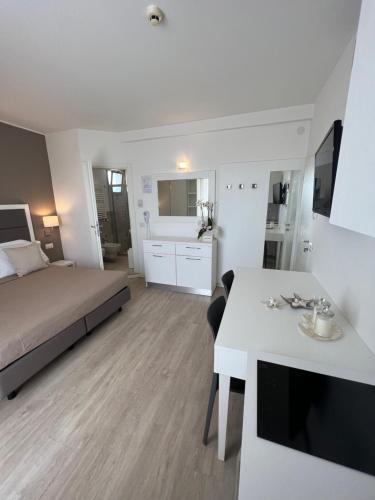 una camera con letto e tavolo bianco di Hotel Ardea a Riccione