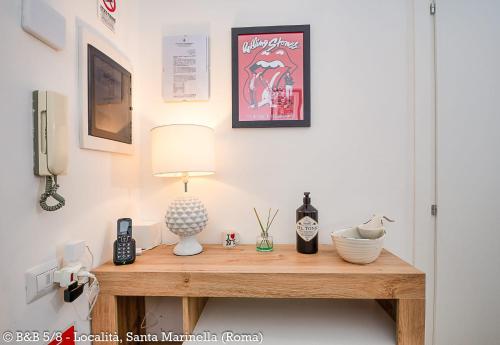 a room with a table with a lamp and a phone at CINQUE OTTAVI B&B in Santa Marinella