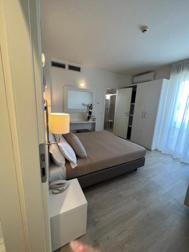 a bedroom with a large bed and a room with at Hotel Ardea in Riccione