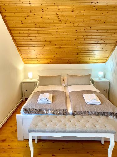 a bed in a room with a wooden ceiling at BorászPorta in Villány