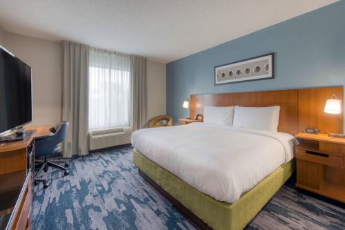 a hotel room with a large bed and a flat screen tv at Fairfield Inn & Suites Raleigh Crabtree Valley in Raleigh