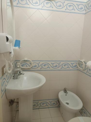 a white bathroom with a sink and a toilet at Almaran B&B Trapani port & city in Trapani