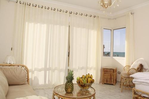 een woonkamer met een tafel met een fruitschaal erop bij Villa Anna & Snake in Hurghada
