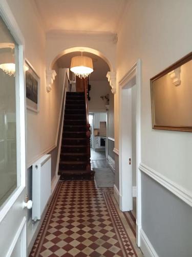 a hallway with a staircase with a checkered floor at Private rooms with breakfast in Bishop Auckland in Bishop Auckland