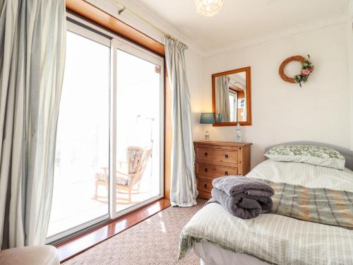 a bedroom with a bed and a large window at Chy Bean in Abergele