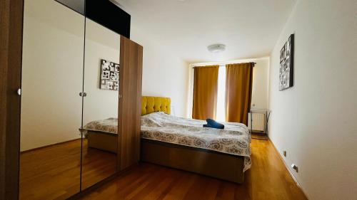Dormitorio pequeño con cama y espejo en Apartment Hurka - 15 min do centra, garaz, en Praga