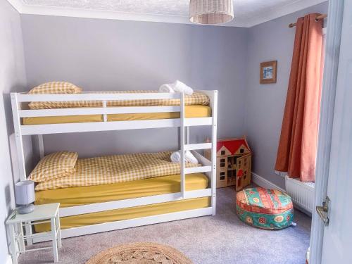 a bedroom with two bunk beds in a room at The Yellow House in Gorleston-on-Sea
