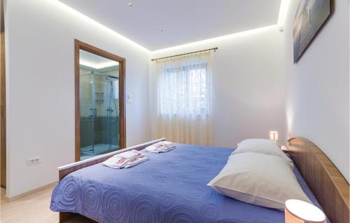 a bedroom with a blue bed and a mirror at Stunning Home In Sisan With Outdoor Swimming Pool in Šišan
