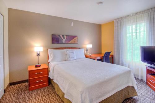 a hotel room with a bed and a television at TownePlace Suites Raleigh Cary/Weston Parkway in Cary