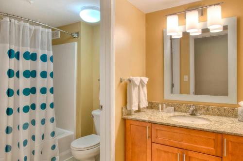 La salle de bains est pourvue d'un lavabo, de toilettes et d'un miroir. dans l'établissement TownePlace Suites Raleigh Cary/Weston Parkway, à Cary