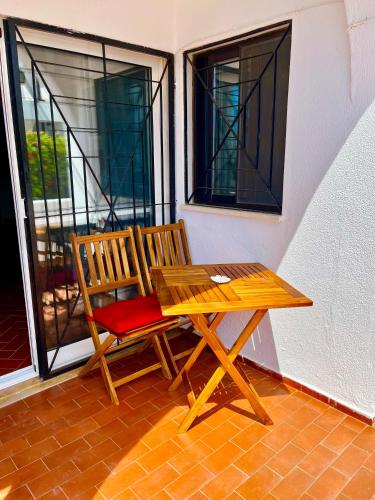 a wooden table and two chairs sitting on a porch at CasAzul in Olhão