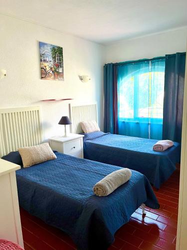 a bedroom with two beds and a window at CasAzul in Olhão