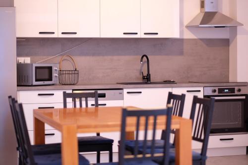 a kitchen with a wooden table and chairs in a kitchen at Krasa Escape in Novi Vinodolski