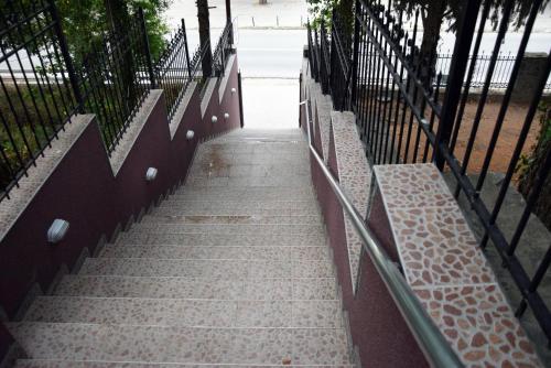 un conjunto de escaleras con una valla y bancos en Vila Marija - Teo, en Star Dojran