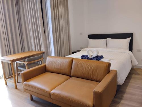a hotel room with a bed and a couch at Tay Residence in Bangkok