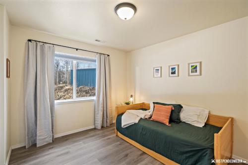 a bedroom with a bed and a window at Skeetawk Ski Lifts - Hatcher Pass Mountain Home Rental Palmer Alaska in Palmer