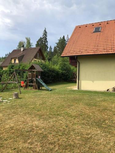a yard with a house and a playground at chata ORAVSKA priehrada in Námestovo