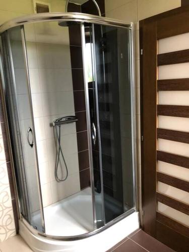 a shower with a glass door in a bathroom at chata ORAVSKA priehrada in Námestovo