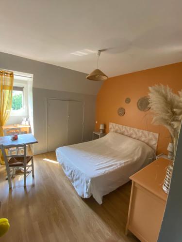 een slaapkamer met een wit bed en een tafel bij Moulin de Latouille in Latouille-Lentillac