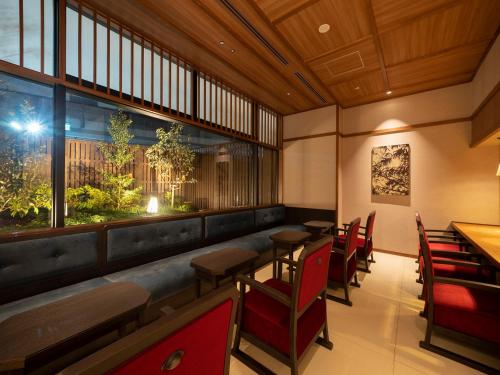 a restaurant with tables and chairs and a large window at Kyoto Umekoji Kadensho in Kyoto