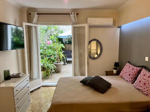Schlafzimmer mit einem Bett und einer Glasschiebetür in der Unterkunft Modern Apartment in The Heart of Athens Near Acropolis in Athen
