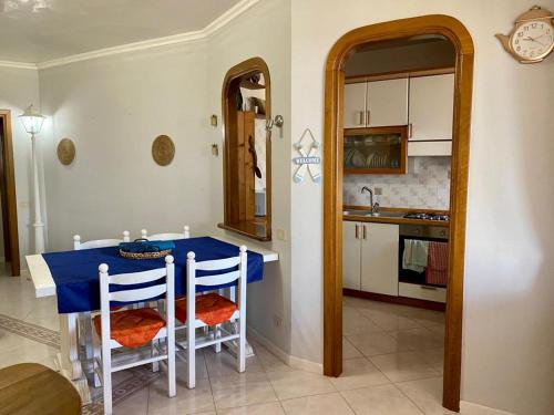 una cucina con tavolo blu e alcune sedie di Sperlonga Paradise Villetta a Sperlonga