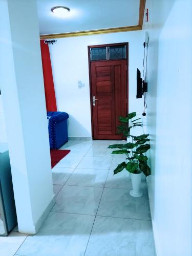 un couloir avec une porte rouge et une plante dans l'établissement Bamburi Luxury Homes 2, à Bamburi
