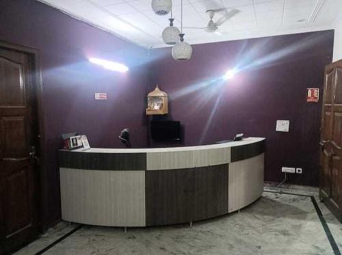 a waiting room with a counter and a purple wall at OYO Gupta Guest House in Morādābād