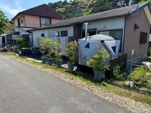 a row of potted plants next to a house at ゲストハウス れんげ苑 in Shimosato
