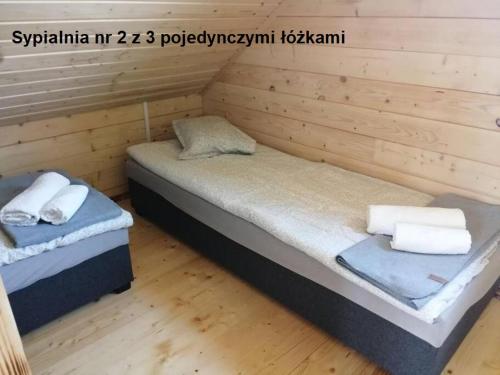 Habitación con 2 camas en una cabaña de madera en Uroczy nowy domek, en Karwik