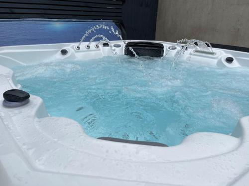 a bath tub with water pouring into it at Hot Tub, Newly refurbished 4 bed, Dog friendly. in Torquay