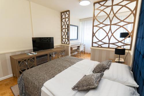 Schlafzimmer mit einem Bett, einem Schreibtisch und einem TV in der Unterkunft Artearia Hotel in Bjelovar