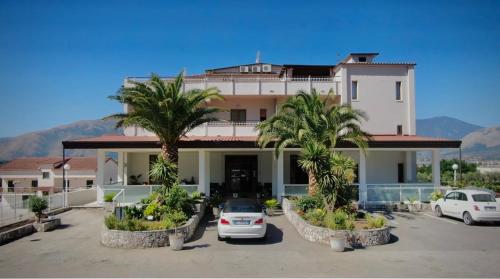 a large building with palm trees in front of it at Hotel Vallisdea in Sala Consilina