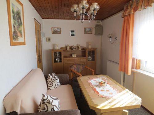 ein kleines Wohnzimmer mit einem Tisch und einem Sofa in der Unterkunft Urlaub im Harz/Wernigerode unterhalb vom Schloss in Wernigerode
