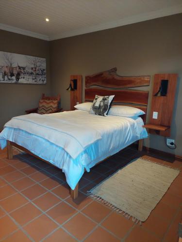 a bedroom with a large bed with a wooden headboard at Allo Allo in Boksburg