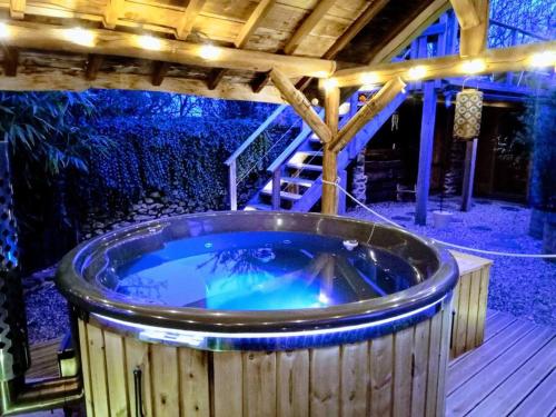 une baignoire jacuzzi sur la terrasse la nuit dans l'établissement La Cabane des Colibris, à Rieupeyroux