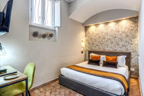 a hotel room with a bed and a desk and a chair at Maison Babuino in Rome