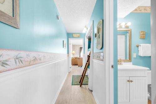 une salle de bains aux murs bleus et un couloir avec lavabo. dans l'établissement The Summit 928, à Panama City Beach