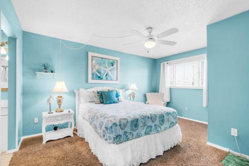 - une chambre bleue avec un lit et un ventilateur de plafond dans l'établissement The Summit 928, à Panama City Beach