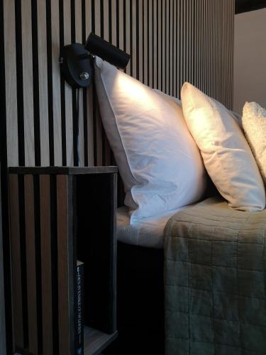 a couch with two pillows on it next to a wall at Annavälla gårdshus in Skurup