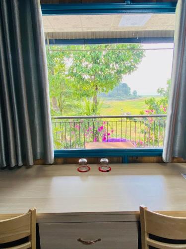 a window with a pair of glasses sitting on a desk at Bến Hồ Homestay in Xã Gia Tân