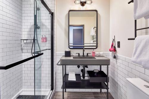 a bathroom with a sink and a mirror at Moxy Columbus Short North in Columbus