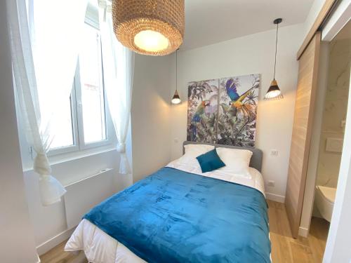 Un dormitorio con una cama azul y una pintura en la pared en 06AN - Bel appartement au cœur du Vieil Antibes, en Antibes