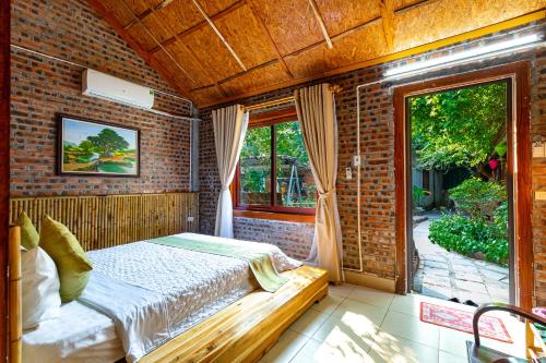 Un dormitorio con una cama en una pared de ladrillos. en Green Peace Bungalow, en Ninh Binh